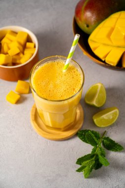 Taze mango, nane ve limonlu bir bardakta mango kokteyli.
