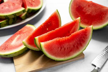 Kesme tahtasında taze kırmızı sulu karpuz dilimleri