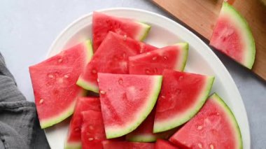 Taze kırmızı sulu karpuz dilimleri bir tabakta, üst manzara. Yaz taze meyve atıştırması