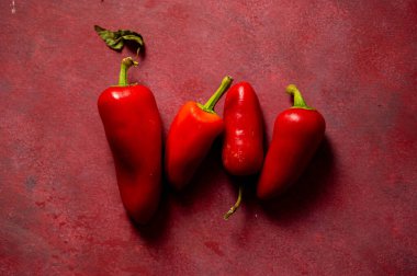 Kırmızı arkaplanda kırmızı biber, üst görünümde.