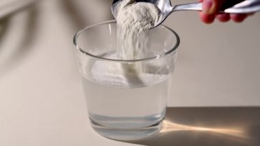 Bir bardak suya kolajen tozu ekliyorum. Sağlıklı olmak için gıda takviyesi.