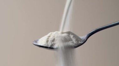Kolajen protein tozu kaşığa dökülüyor. Gıda güzelliği ve sağlık desteği.