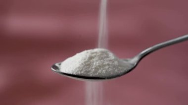 Kolajen protein tozu kaşığa dökülüyor. Gıda güzelliği ve sağlık desteği.
