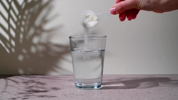 コラーゲンタンパク質粉末が水でガラスに注がれている 食品の美しさと健康補助食品 — ストック動画