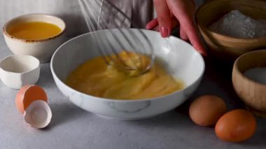 Metal tel çırpıcıyla kasede yumurta çırpmak. Yemek pişirme, pişirme, kahvaltı