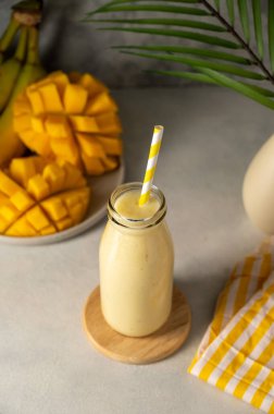 Bottle of mango, banana and yoghurt smoothie with a straw