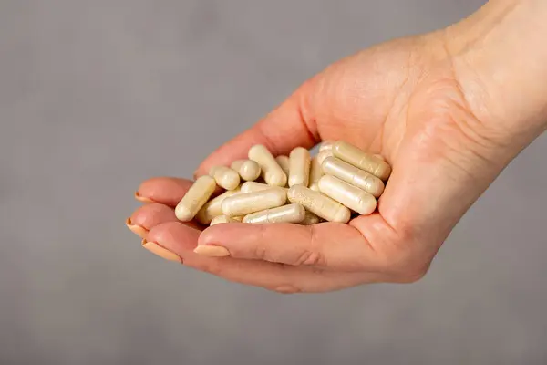 Weibliche Hände Halten Einen Haufen Kapseln Kollagen Vitamine Schmerzmittel Nahrungsergänzungsmittel lizenzfreie Stockbilder