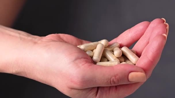白いカプセル コラーゲン ビタミン 痛み殺人者 食品サプリメントの丸薬のヒープを握っている女性の手 — ストック動画