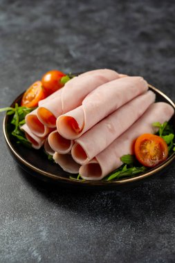 Koyu arkaplanda lezzetli jambon dilimleri var..