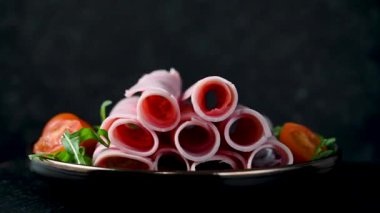 Koyu arkaplanda lezzetli jambon dilimleri var..