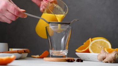 Bağışıklık güçlendirici içeceği bardağa dolduruyorum. Zencefil, portakal, zerdeçal, sağlıklı meyve suyu..