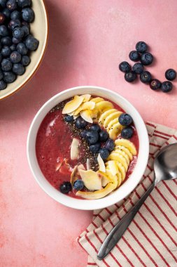 Meyve suyu kasesi, taze yaban mersini, ahududu, muz ve chia tohumlu çilekli smoothie..