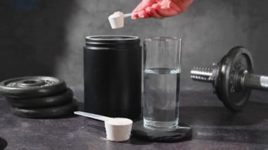 Amino asit takviyesi, ölçü kepçesinde kreatin tozu ve plastik kavanoz..