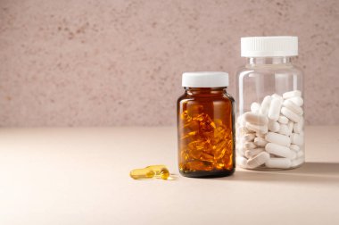 Beyaz haplar ve Omega 3 hapları, kahverengi ve şeffaf kavanozda, gıda takviyeleri, ilaçlar, antibiyotikler