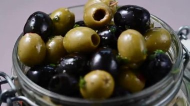 Cam bir kavanozda siyah ve yeşil zeytin. Lezzetli, marine edilmiş zeytin. Akdeniz yemekleri