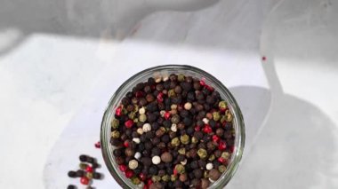 Karışık biberli mısır. Cam bir kavanozda siyah, kırmızı ve beyaz biber.