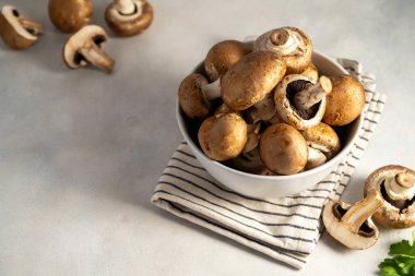 Bir kasede çiğ şampiyon, parlak arka planda, düğmeli mantarlar. Vegan proteini