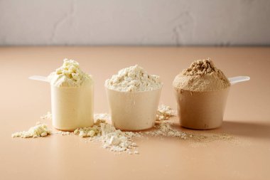 Kepçe içinde protein tozu. Sütlü protein tozlarının farklı tatları