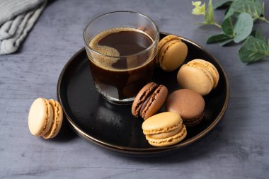 Macarons cookies with coffee, stack of french macarons in a plate.  clipart