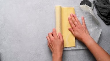 Kadın eli, elleri masanın üstünde çiğ hamur işi yuvarlıyor. Puf böreği pişiriyorum..