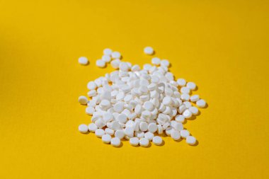 Şeker ikamesi, sarı arka planda tatlandırıcı haplar. Yiyecek takviyesi. Şeker hastası, aşırı kilolu, sağlık konsepti. 