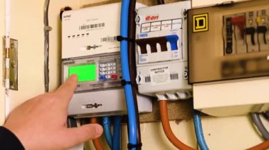 Corby, İngiltere, 1 Ocak 2025 doğalgaz ölçer evde, bir erkek işçi elektrik sayacı sayacından notlar alıyor. Elektrik faturalarının kullanımı için fiyat artıyor