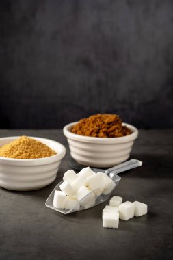 Farklı tipte şeker, açık kahverengi, koyu kahverengi ve beyaz şeker küpleri.