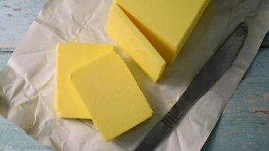 Tereyağı bloğu, çim ile beslenen tereyağı dilimleri tahta kesme tahtasında. D vitamini ve yağ kaynağı 