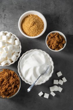 Farklı tipte şeker, açık kahverengi, koyu kahverengi ve beyaz şeker küpleri.