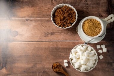 Açık kahverengi, koyu kahverengi ve beyaz şeker küpleri kaselerde. Farklı tür şeker..