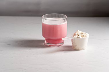 Collagen powder. Protein pink drink and powder in a scoop clipart