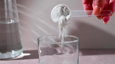 Amino asit takviyesi, ölçü kepçesinde kreatin tozu ve plastik kavanoz..