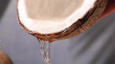 Taze hindistan cevizi suyu akıyor, yavaş çekimde.