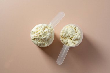 Protein tozu. Vanilya aromalı protein tozu kepçelerde, yakın plan.