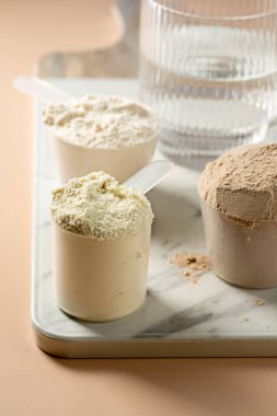 Kepçe içinde protein tozu. Sütlü protein tozlarının farklı tatları