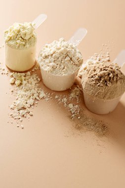 Kepçe içinde protein tozu. Sütlü protein tozunun farklı aromaları, kopyalama alanı
