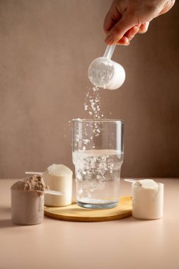 Bir bardağa kolajen kreatin tozu dökülüyor. Gıda desteği, fitness sporu, sağlık ve beslenme