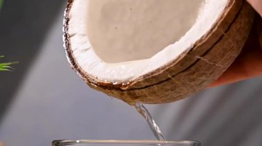 Hindistan cevizinden taze hindistan cevizi suyu dökülüyor.