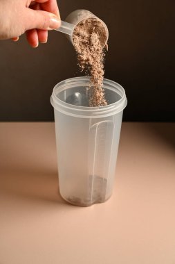 Çikolata protein tozunu karıştırma, gıda takviyesi konsepti..