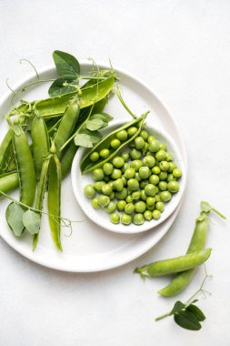  Beyaz tabakta taze bezelye, kopyalama alanı. 