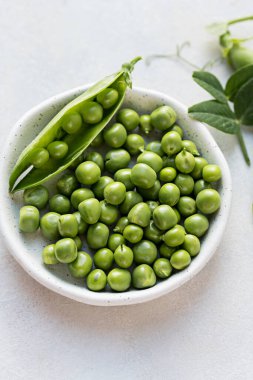 Beyaz tabakta taze taze bezelye. Makro fotoğrafçılık. 