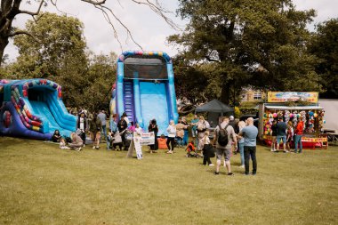 Corby, İngiltere, 1 Haziran 2025. Kalabalık insanlar ve parktaki zıplayan şatolar, aile eğlence fuarı etkinliği.