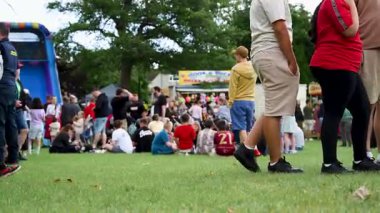 Corby, İngiltere, 1 Haziran 2025. Bir yaz festivali için parkta yürüyen kalabalık.