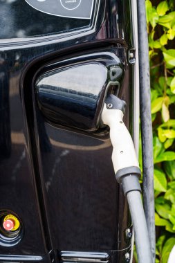 Corby, İngiltere, Haziran 2025: Elektrikli araç EV 'ye şarj güç kablosu prize takıldı.