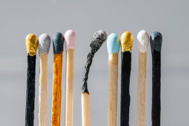 Renkli kibritler ve yanmış bir kibrit. Çeşitlilik, kapsama soyut kavram.