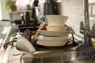 Mutfaklardaki kirli bulaşıklar batar, günlük ev işleri, evi temizler..