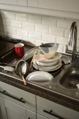 Mutfaklardaki kirli bulaşıklar batar, günlük ev işleri, evi temizler..