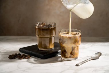Sütü kahvenin üzerine dökmek, buzlu kahve yapmak.
