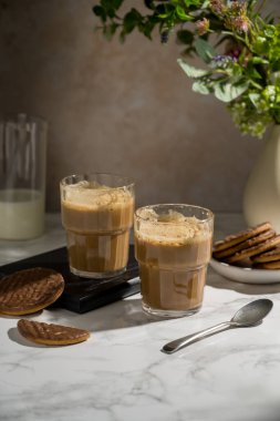 Çikolatalı kurabiye ile servis edilen bardakta buzlu latte..