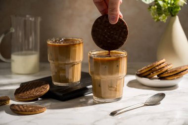 Çikolatalı kurabiye ile servis edilen bardakta buzlu latte..